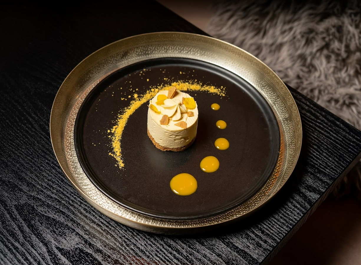 Plated dessert with mango coulis on brass platter